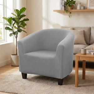 Housse de fauteuil crapaud extensible en tissu doux installée sur un fauteuil arrondi dans un salon chaleureux