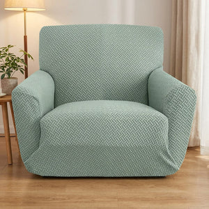 Housse de fauteuil jacquard vert sauge sur un fauteuil une place dans un salon lumineux