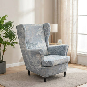 Fauteuil à oreilles avec housse à motif feuillage près d'une fenetre lumineuse