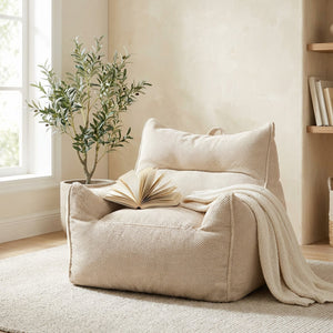 Fauteuil poire beige en coton gaufré dans un coin lecture avec plante et livre