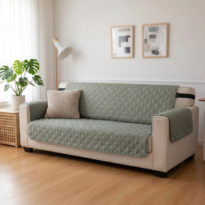 Housse de canapé matelassée grise imperméable installée sur un canapé dans un salon clair