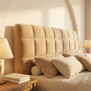 Housse de tête de lit capitonnée beige dans une chambre chaleureuse à la lumière dorée
