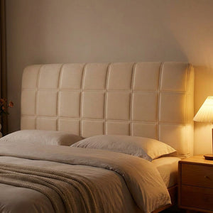 Housse de tête de lit beige matelassée en ambiance chaleureuse de soirée