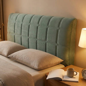 Housse de tête de lit vert sauge dans une chambre chaleureuse éclairée le soir