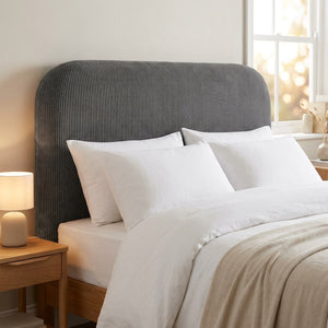 Housse de tête de lit en velours côtelé gris sur un lit dans une chambre lumineuse
