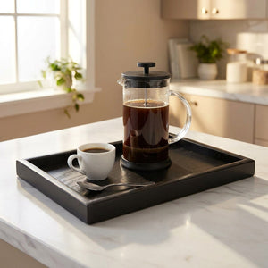 Plateau de service noir sur plan de travail marbre avec cafetière et tasse