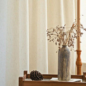 Voilage effet lin près d'une console en bois avec vase et branches séchées