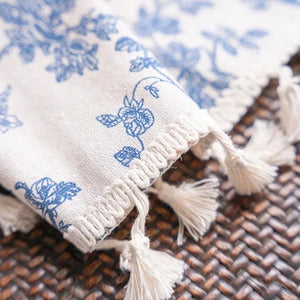 Détail de la bordure à pompons du rideau en lin et coton fleuri