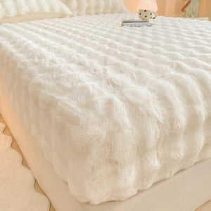 Drap-housse en peluche polaire blanche moelleuse installé sur un lit dans une chambre lumineuse