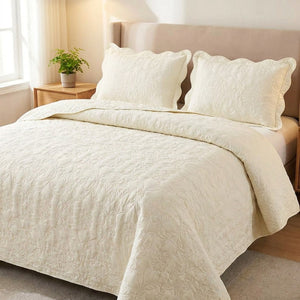 Couvre-lit matelasse ivoire au motif damasse sur un lit avec deux taies assorties