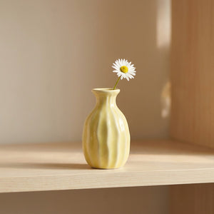 Vase soliflore en céramique côtelé jaune pastel avec une fleur unique