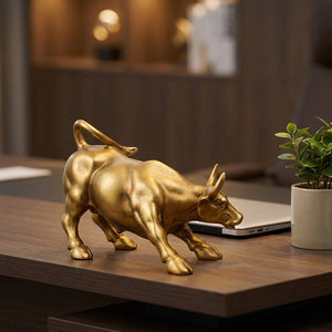 Statue taureau doré sur un bureau en bois avec un ordinateur portable