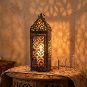 Lanterne marocaine posée sur une table orientale près de verres à thé