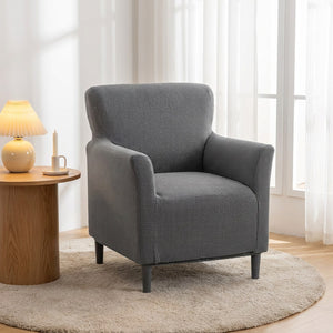 Fauteuil avec housse grise près d'une table d'appoint en bois et une lampe allumée