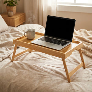 Plateau de lit en bambou avec un ordinateur portable et une tasse posés sur un lit