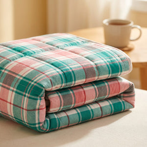 Couverture chauffante pliée montrant le tissu doux au motif tartan vert et rose