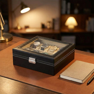 Boîte à montres fermée sur un bureau avec montres visibles sous la vitre