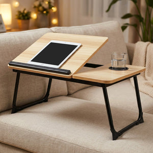 Table de lit en bambou avec une tablette et un verre d'eau posée sur un canapé