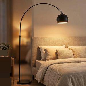 Lampadaire arc noir allumé dans une chambre cosy