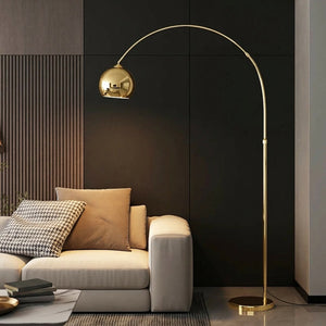 Lampadaire arc doré dans salon sombre avec canapé beige