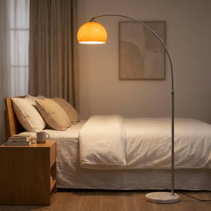Lampadaire arc globe verre orange allumé dans chambre nordique