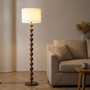 Lampadaire boulier bois dans un salon japandi avec canapé beige, lumière tamisée