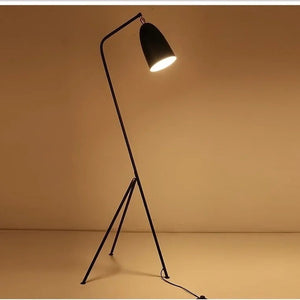 Lampadaire grasshopper allumé diffusant une lumière ambrée chaleureuse