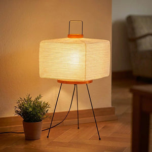 Lampadaire japonais sur trépied en papier de riz allumé dans un salon cosy