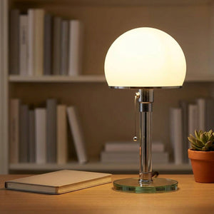 Lampe de table Bauhaus sur un bureau avec un carnet et une plante grasse