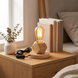 Lampe de table en bois posée sur une table de chevet avec des livres et une plante séchée