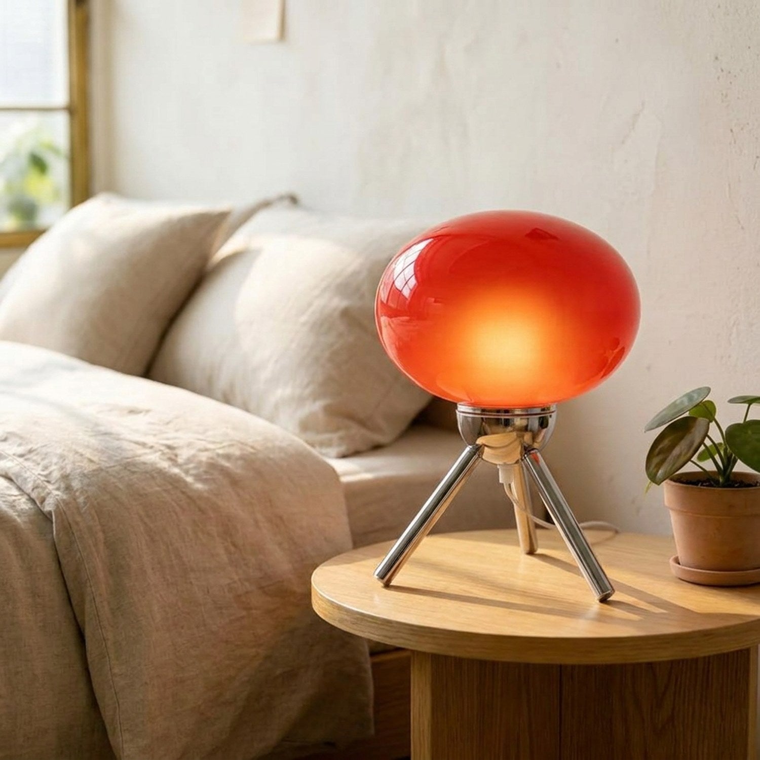 Lampe de chevet champignon rouge allumée près d'un lit dans une chambre scandinave