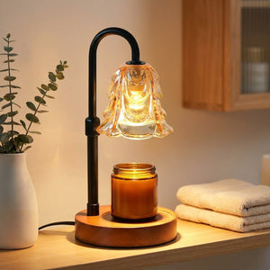 Lampe chauffe-bougie fleur ambrée sur une étagère de salle de bain avec eucalyptus et serviettes moelleuses