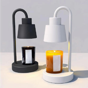 Lampe chauffe-bougie noire et blanche avec bougie parfumée allumée en gros plan