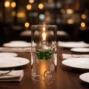 Lampe à huile ouragan avec liquide vert sur une table dressée pour un dîner