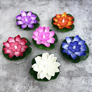 Lampes lotus flottantes LED de toutes les couleurs posees sur leurs feuilles