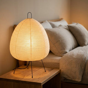 Lampe de table conique en papier de riz style Noguchi sur chevet, lumière chaude allumée