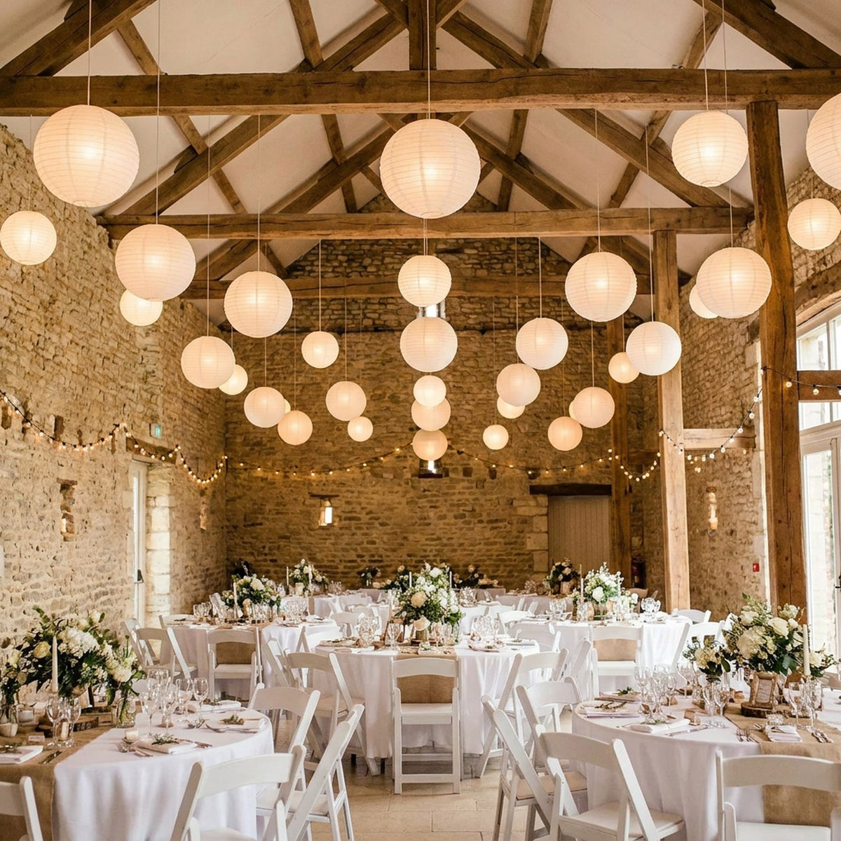 Lanternes papier blanc suspendues décoration mariage grange pierre
