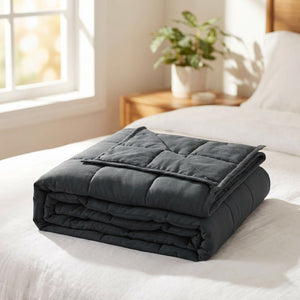 Couverture lestée grise pliée au pied d un lit dans une chambre lumineuse