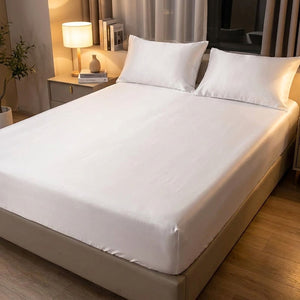 Drap-housse blanc satin brossé sur un lit dans une chambre moderne avec lampe de chevet