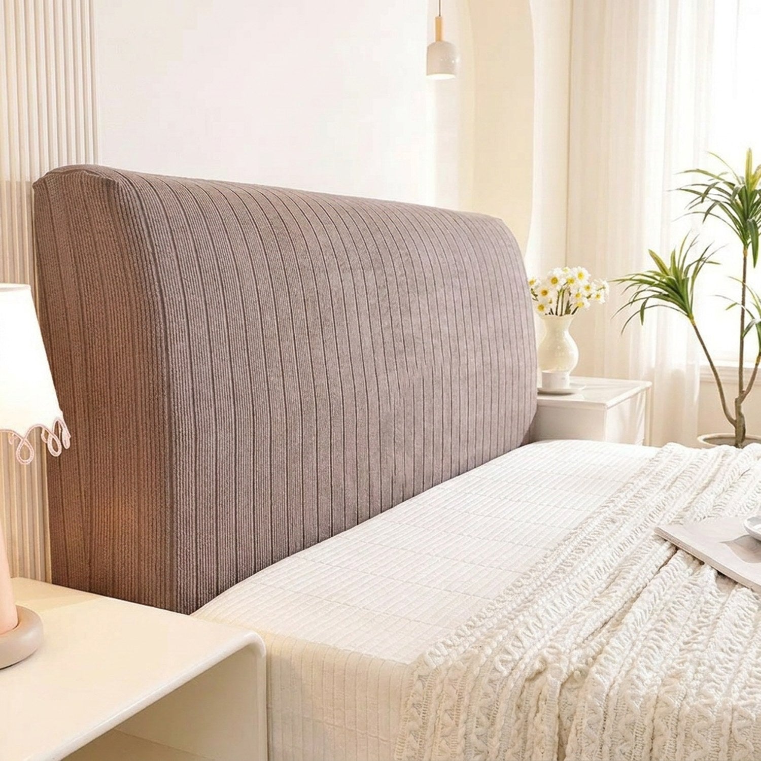 Housse de tête de lit taupe habillant un lit dans une chambre claire et cosy