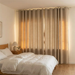 Rideau occultant beige effet lin fermé devant une fenêtre dans une chambre chaleureuse