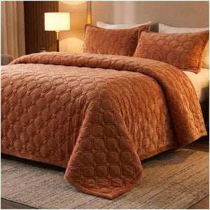 Couvre-lit matelassé terracotta au pied du lit avec lampe de chevet allumée