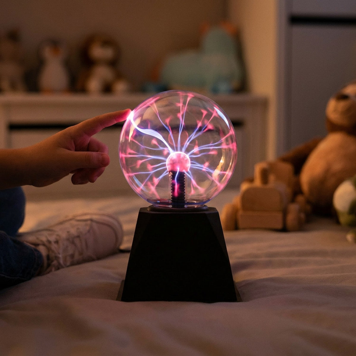 Main d'enfant touchant une lampe boule de plasma allumée dans une chambre