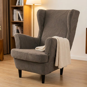 Fauteuil bergère taupe à motif jacquard dans un coin lecture avec plaid