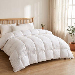 Couette blanche installée sur un grand lit dans une chambre lumineuse au style scandinave