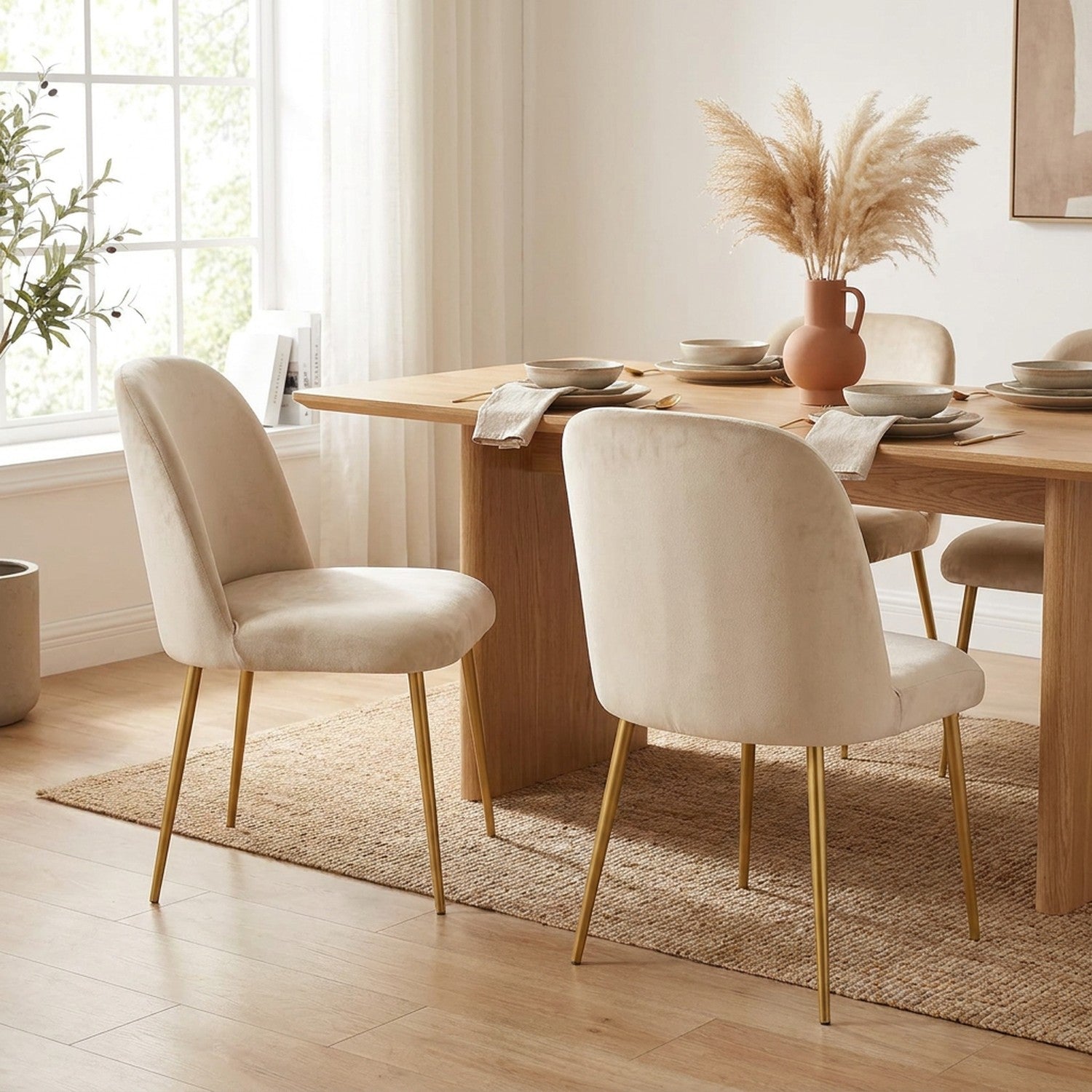 Deux chaises avec housse de protection en velours beige autour d'une table à manger