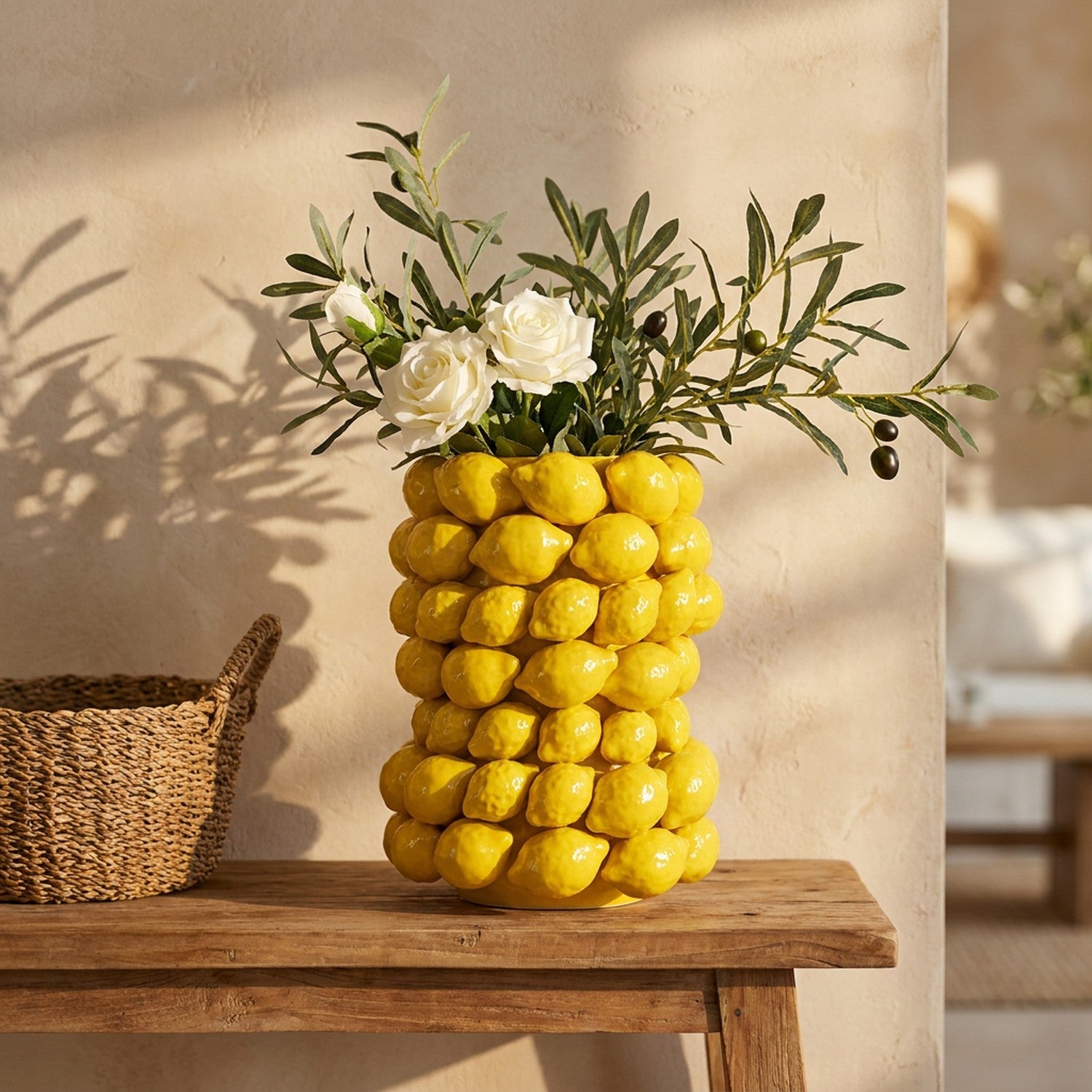 Vase citron en céramique jaune posé sur une console en bois avec un panier en osier dans un intérieur méditerranéen