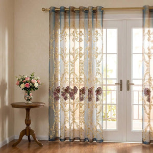 Rideau voilage tulle brodé devant une porte fenêtre dans un salon romantique avec vase de fleurs