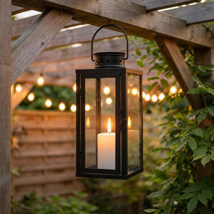 Lanterne à bougie suspendue à une pergola dans un jardin éclairé le soir