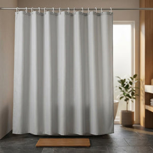 Rideau de douche gris dans une salle de bain minimaliste avec tapis en teck